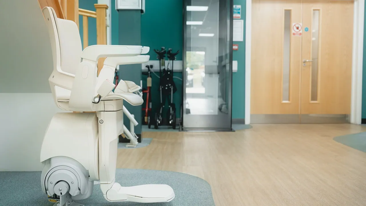 Modern stair lift with folded seat on a straight staircase