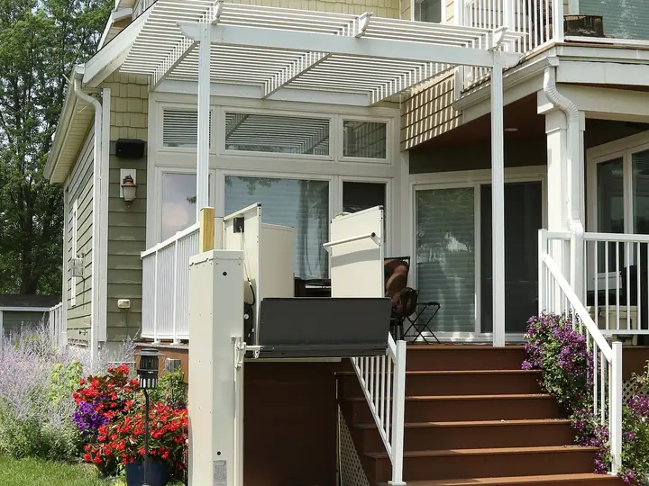 Vertical platform lift beside the steps of a home