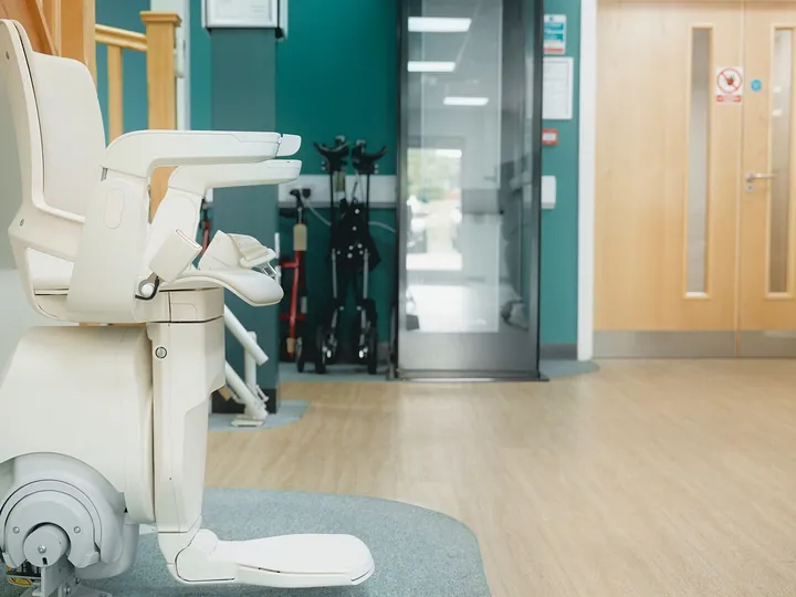 Modern stair lift with folded seat on a straight staircase